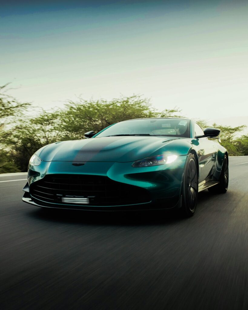 A blue sports car driving down a road